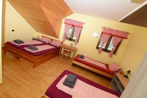 a bedroom with two beds and a wooden ceiling at Podveský mlýn in Tlumačov