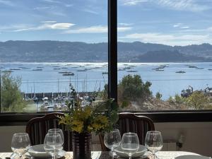 - une table avec des verres à vin et une vue sur le port dans l'établissement Mirador Puerto Náutico, à Moaña
