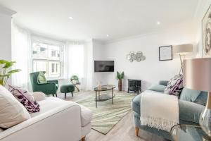 ein Wohnzimmer mit einem Sofa und einem Tisch in der Unterkunft Skye Sands - City Road Residence - Central St Andrews in St Andrews