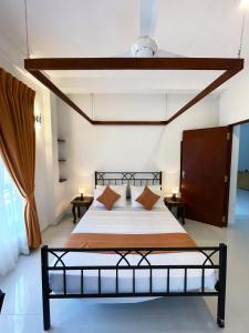 a bedroom with a black bed with orange pillows at Zeleny Apartments in Nugegoda +20 photos