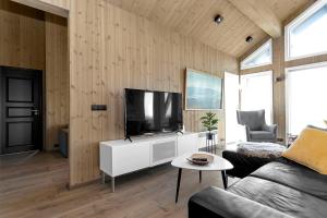 a living room with a flat screen tv on a wall at Luxury Country Cottage with 360° Mountain View in Brautarholt