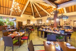 um restaurante com mesas e cadeiras de madeira e uma cafetaria em Risata Bali Resort & Spa em Kuta
