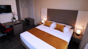 Schlafzimmer mit einem Bett, einem Schreibtisch und einem TV in der Unterkunft Blu Hotel in Buccinasco