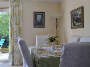 a dining room table with a vase of flowers on it at Riverside in Newton Stewart