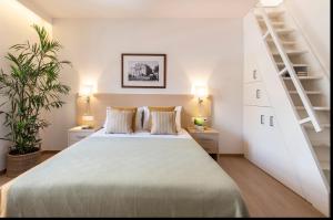 1 dormitorio blanco con 1 cama grande y escaleras en Gallery Suites & Residences, en Pireo