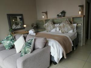 Un dormitorio con una cama grande y un sofá. en Lavandula Manor Self-Catering, en Mossel Bay 35 fotos más