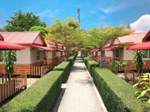 une rangée de maisons avec des haies vertes et des toits rouges dans l'établissement Phi Phi Ba Kao Bay Resort, sur les Îles Phi Phi