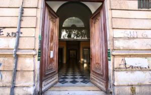 een ingang naar een oud gebouw met een geruite vloer bij Loft “Cinema Galleria” in Bari