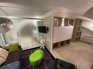 een woonkamer met een bank en een groene kruk bij Loft “Cinema Galleria” in Bari