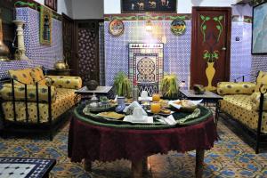 una sala de estar con una mesa con comida. en Maison Adam, en Fez