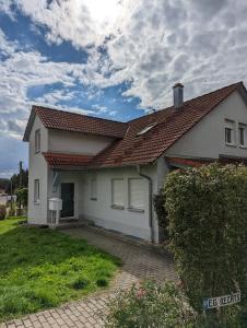 a white house with a red roof at FeWo Grenzenlos in Ramsberg in Pleinfeld