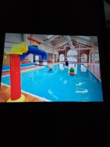 uma grande piscina com escorrega aquático em Deluxe 3 bedroom Lyons Robin hood oaklands with free wifi free sky em Meliden