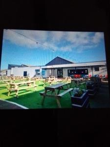 a picnic table in front of a building at Deluxe 3 bedroom Lyons Robin hood oaklands with free wifi free sky in Meliden