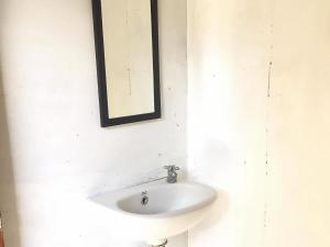 Olala Bungalows And Restaurant Mitra RedDoorz في باندا أسيه: حمام مع حوض ومرآة على الحائط