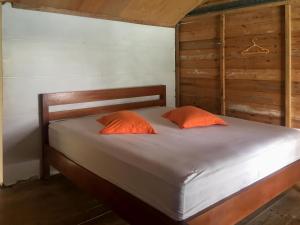 a bed with two orange pillows in a room at Olala Bungalows And Restaurant Mitra RedDoorz in Banda Aceh