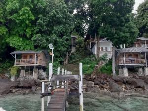 a wooden bridge over a river with houses at Olala Bungalows And Restaurant Mitra RedDoorz in Banda Aceh