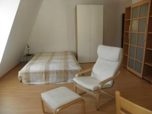 a bedroom with a bed and a chair and a stool at Dependance am Blumenbrunnen in Baden-Baden