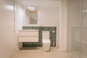 La salle de bains est pourvue de toilettes, d'un lavabo et d'un miroir. dans l'établissement Mayor 36 by Seaward Suites, à La Vila Joiosa