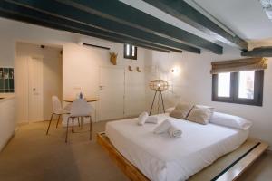 sypialnia z dużym białym łóżkiem i stołem w obiekcie Mayor 36 by Seaward Suites w mieście Villajoyosa