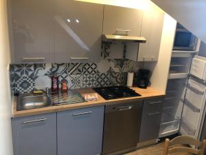 a small kitchen with a sink and a stove at Logement 4 personnes avec piscine intérieure 31 degrés zoo de la FLECHE 24 h du Mans in La Flèche