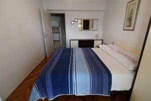 席洛的住宿－App2 Marin，一间卧室配有一张带蓝白色毯子的床