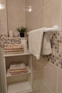 a bathroom with a towel and towels on a shelf at App2 Marin in Šilo