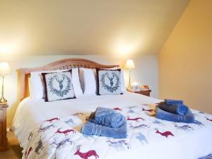 Un dormitorio con una cama con toallas azules. en Glebe Cottage en Urray