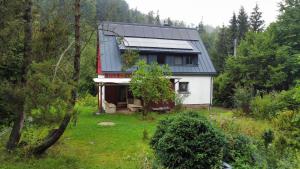 une maison avec un toit solaire dans une forêt dans l'établissement Ferienhaus Waldhäus'l, à Bärenstein