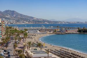 a view of a beach with palm trees and the ocean at SPECTACULAR SEA VIEW Fuengirola in Fuengirola