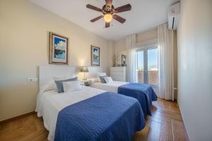 a bedroom with two beds and a ceiling fan at SPECTACULAR SEA VIEW Fuengirola in Fuengirola