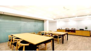 a classroom with tables and chairs and a kitchen at Alana Townhouse in Vijayawāda