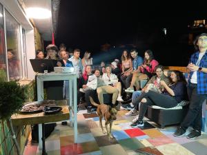 un grupo de personas sentadas en una habitación con un perro en Hakuna Matata Guest House en Plovdiv