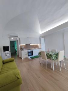 a living room with a couch and a table and chairs at GDB HOUSE in Molfetta