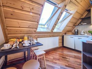 kuchnia ze stołem w pokoju z oknem w obiekcie VisitZakopane - Tetmajera Apartment w Zakopanem