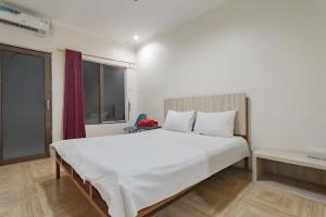 a bedroom with a large white bed and a window at RedDoorz Syariah at Cigadung Raya Street in Bandung