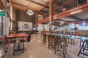 a restaurant with tables and chairs in a room at RedDoorz Syariah at Cigadung Raya Street in Bandung