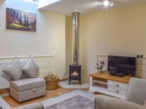 a living room with a fireplace and a tv at The Stables At Early Autumn in Eynsford