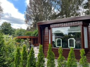 een klein huis met een raam in een tuin bij Veluwe Park Reewold Chalet Vision in Putten