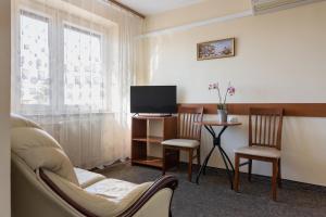 a living room with a tv and chairs and a table at Mixbud in Biała Podlaska