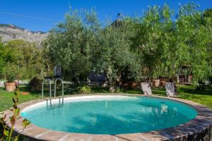 una piscina en un patio con 2 sillas en Limosa Country House, en Spigno Saturnia