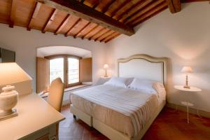 um quarto com uma cama, uma secretária e 2 candeeiros em Borgo Sant'Ambrogio - Resort em Pienza