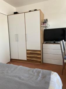 - une chambre avec un lit, une télévision et des armoires blanches dans l'établissement Fehmarn Ostseeferien FeWo Südstrand192, à Burgtiefe auf Fehmarn 
