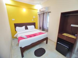 a small bedroom with a bed with a red blanket at Hotel Candolim Aloft in Candolim