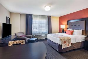 a hotel room with a large bed and a desk at Hawthorn Suites by Wyndham Williston in Williston