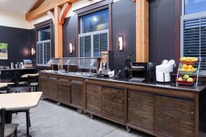 a kitchen with wooden cabinets and a counter top at Hawthorn Suites by Wyndham Williston in Williston