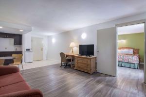 a living room with a bed and a desk with a television at Motel 6-Oriskany, NY in Oriskany