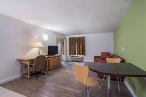 a living room with a desk and a table and chairs at Motel 6-Oriskany, NY in Oriskany