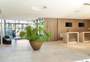 a large plant in the middle of a lobby at elaya hotel kleve in Kleve