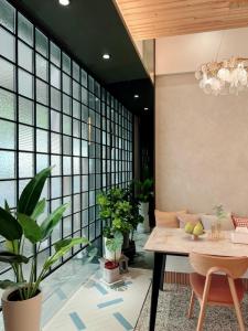 a dining room with a table and potted plants at HoME-Easyhouse-III in Tainan