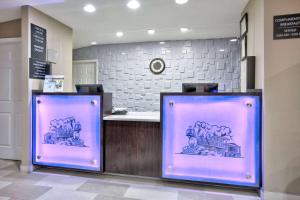 two screens with a train on them in a lobby at Super 8 by Wyndham Palestine TX in Palestine